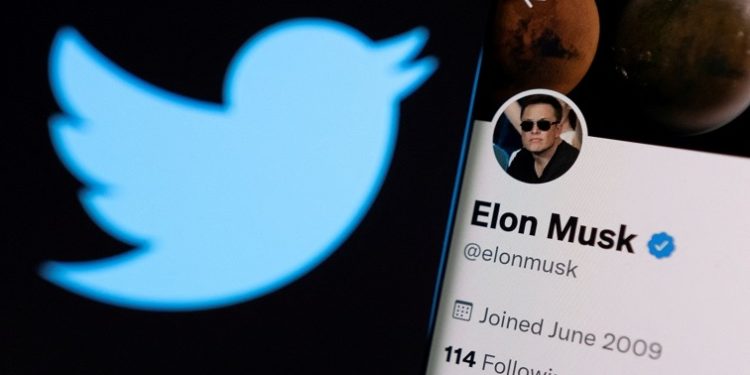 Imagen, La cuenta de Twitter de Elon Musk se ve en un teléfono inteligente frente al logotipo de Twitter en esta ilustración fotográfica tomada el 15 de abril de 2022